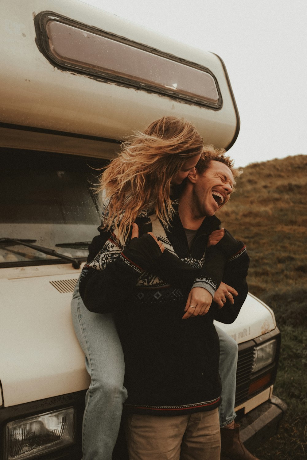 a man and a woman standing in front of a truck