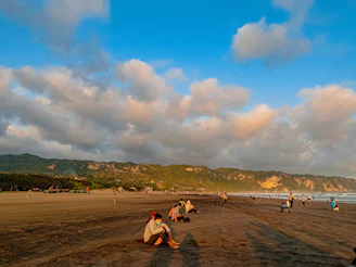 a group of people standing on top of a sandy beach