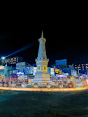 a clock tower lit up at night in a town square