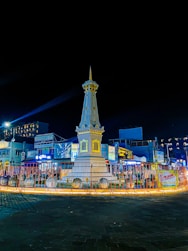 a clock tower lit up at night in a town square