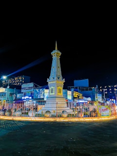 a clock tower lit up at night in a town square