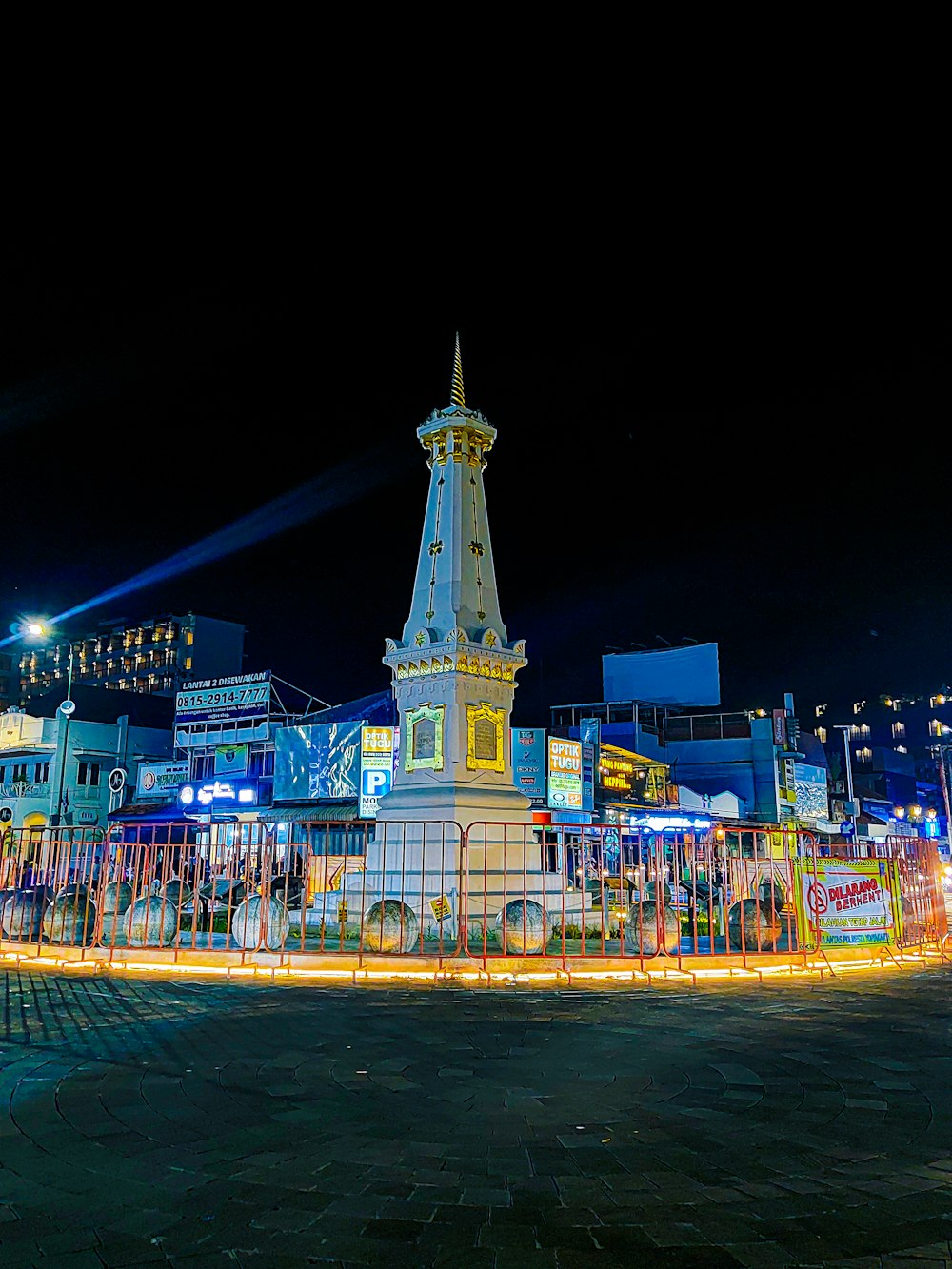 a clock tower lit up at night in a town square