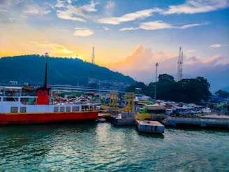 a red and white boat docked in a harbor