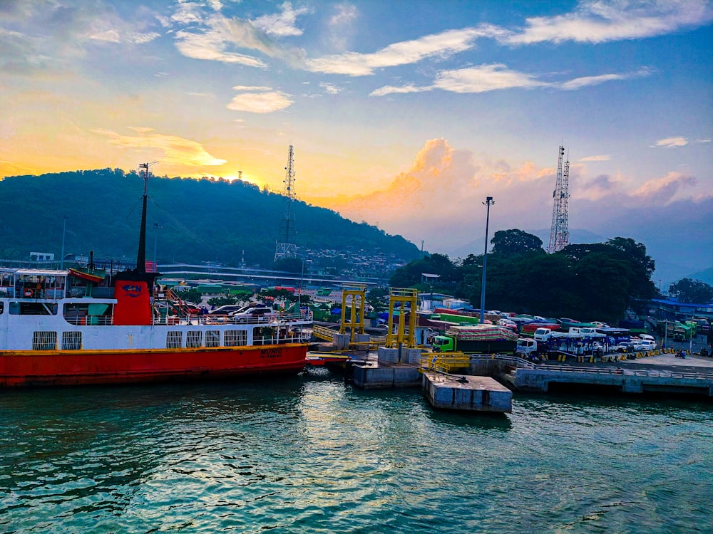 a red and white boat docked in a harbor