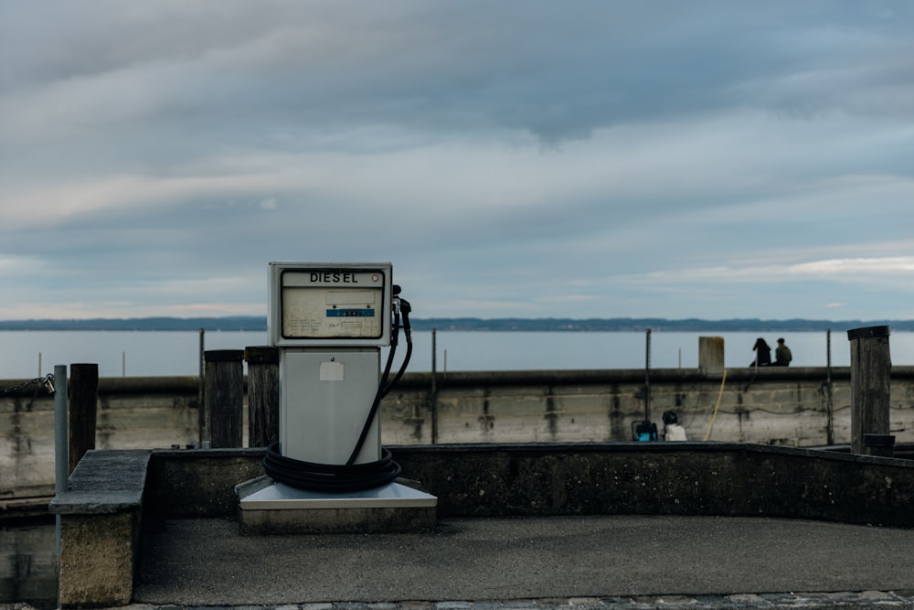 a gas pump sitting on top of a cement wall