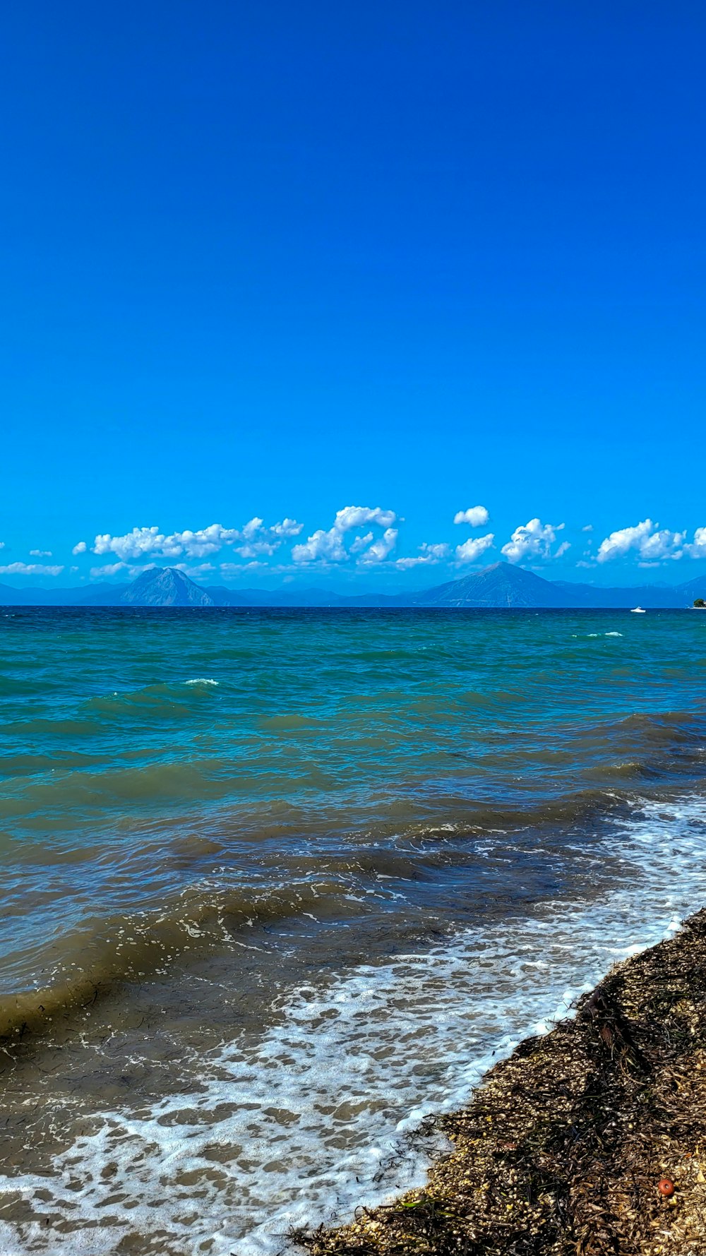 a person walking along the beach with a surfboard