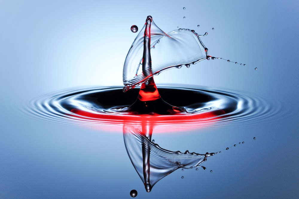 um objeto vermelho flutuando na água em cima de uma superfície azul
