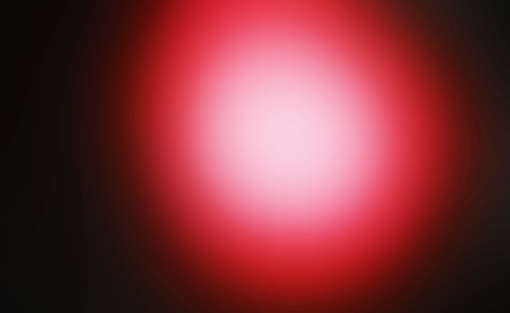 a blurry image of a red ball on a black background