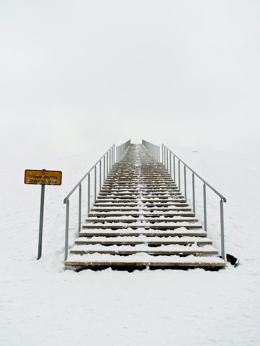 a set of stairs leading up to the top of a snowy hill