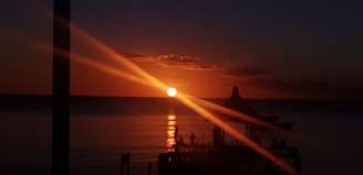 the sun is setting over a body of water
