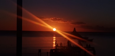 the sun is setting over a body of water