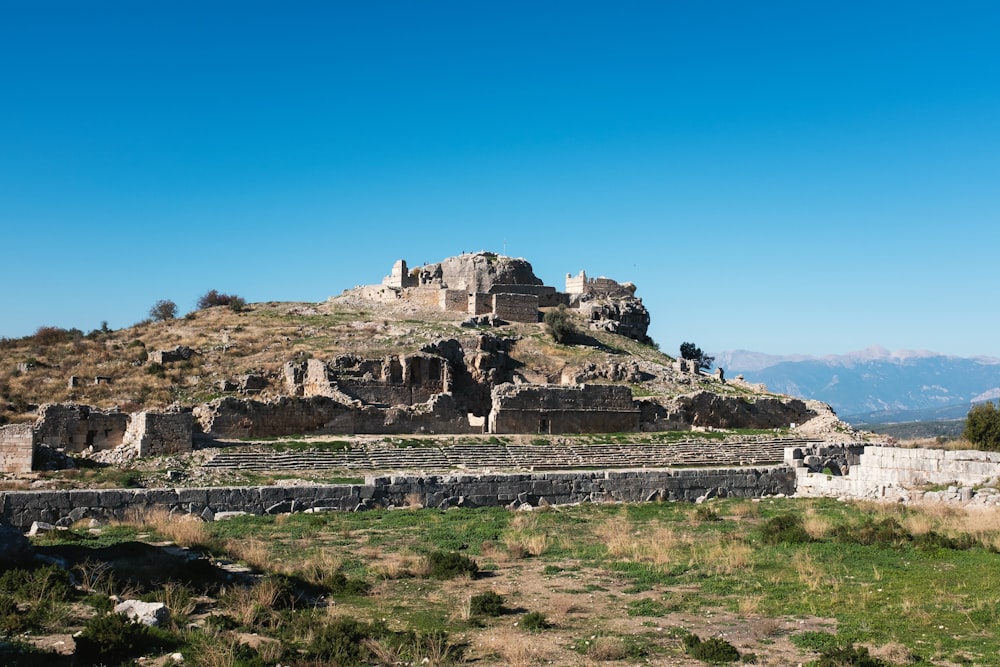 a large stone structure sitting on top of a lush green hillside