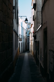 a narrow alley way with a street light in the distance