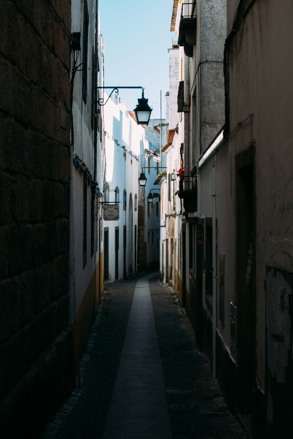 a narrow alley way with a street light in the distance