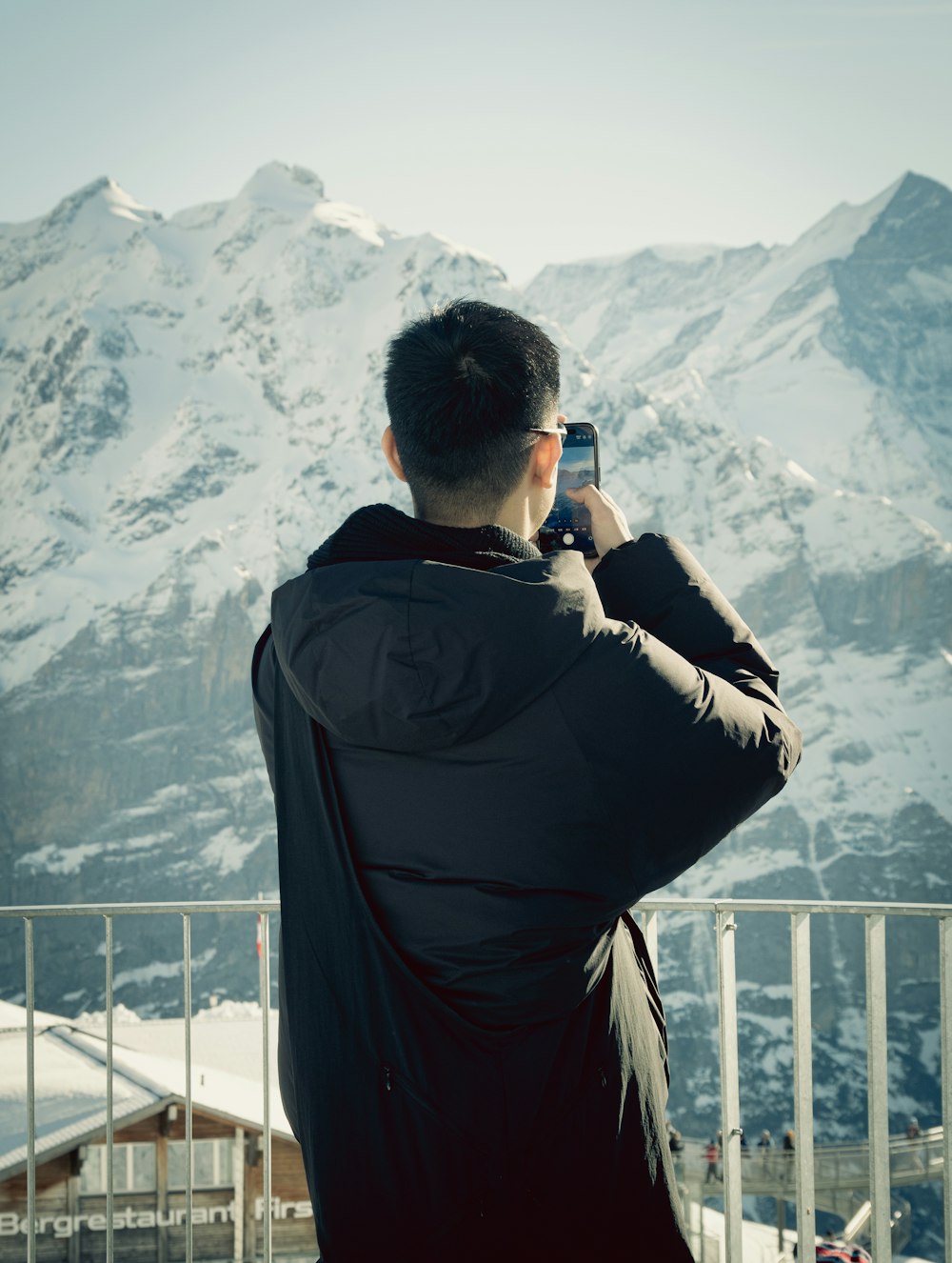 un uomo che scatta una foto di una montagna innevata