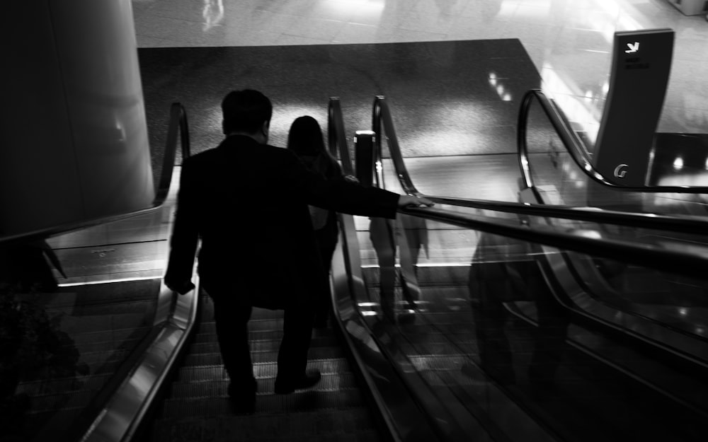 a man and a woman walking down an escalator