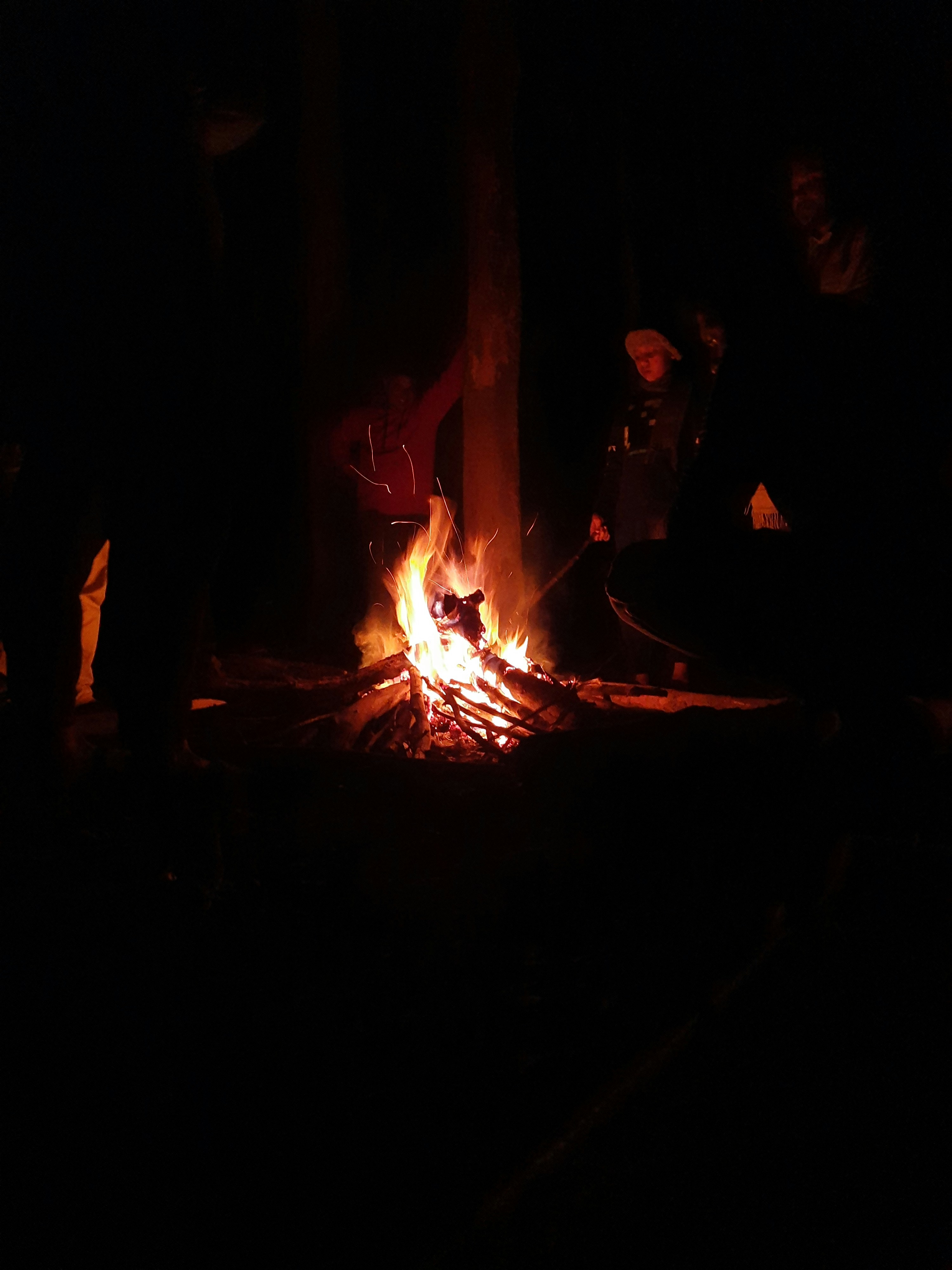 a group of people sitting around a campfire