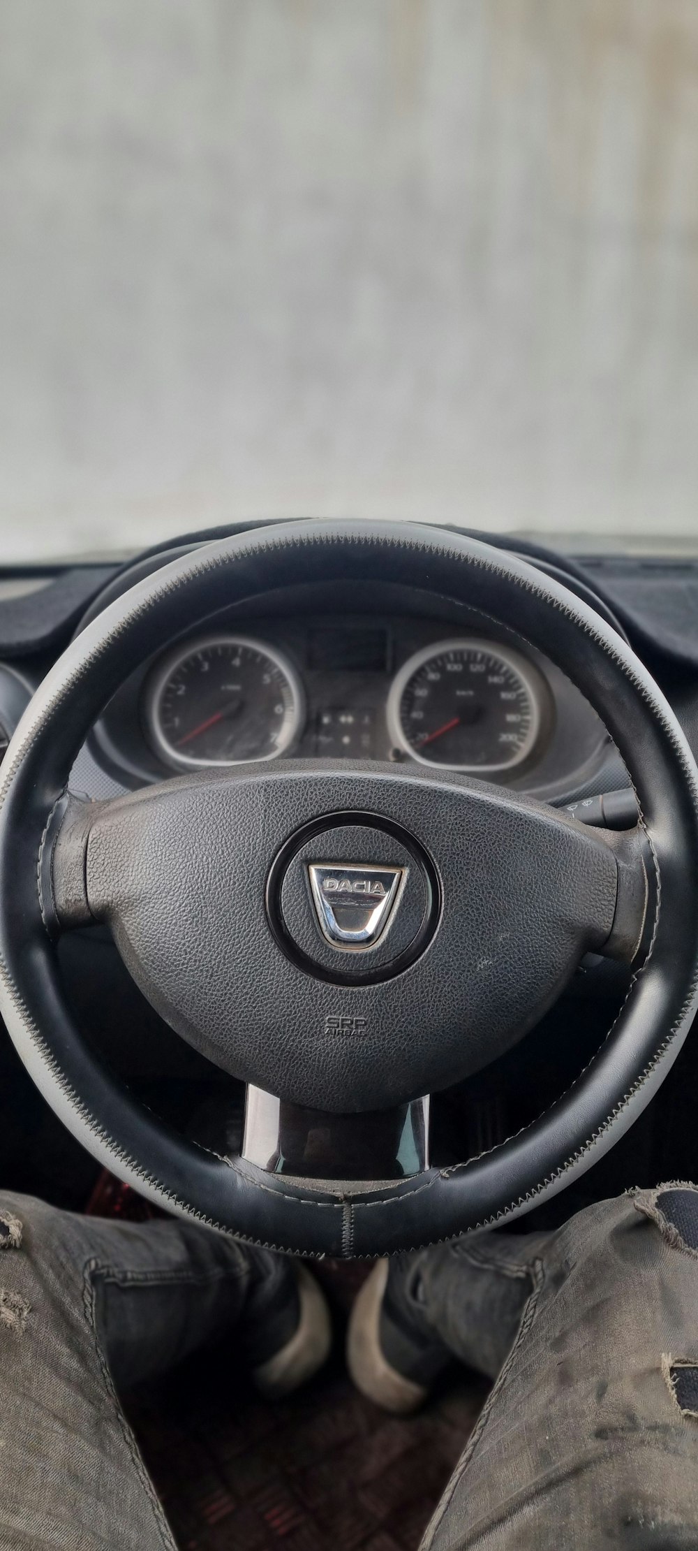 a person sitting in a car with their feet on the steering wheel
