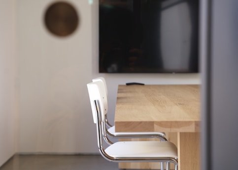 a table with chairs and a television in the background