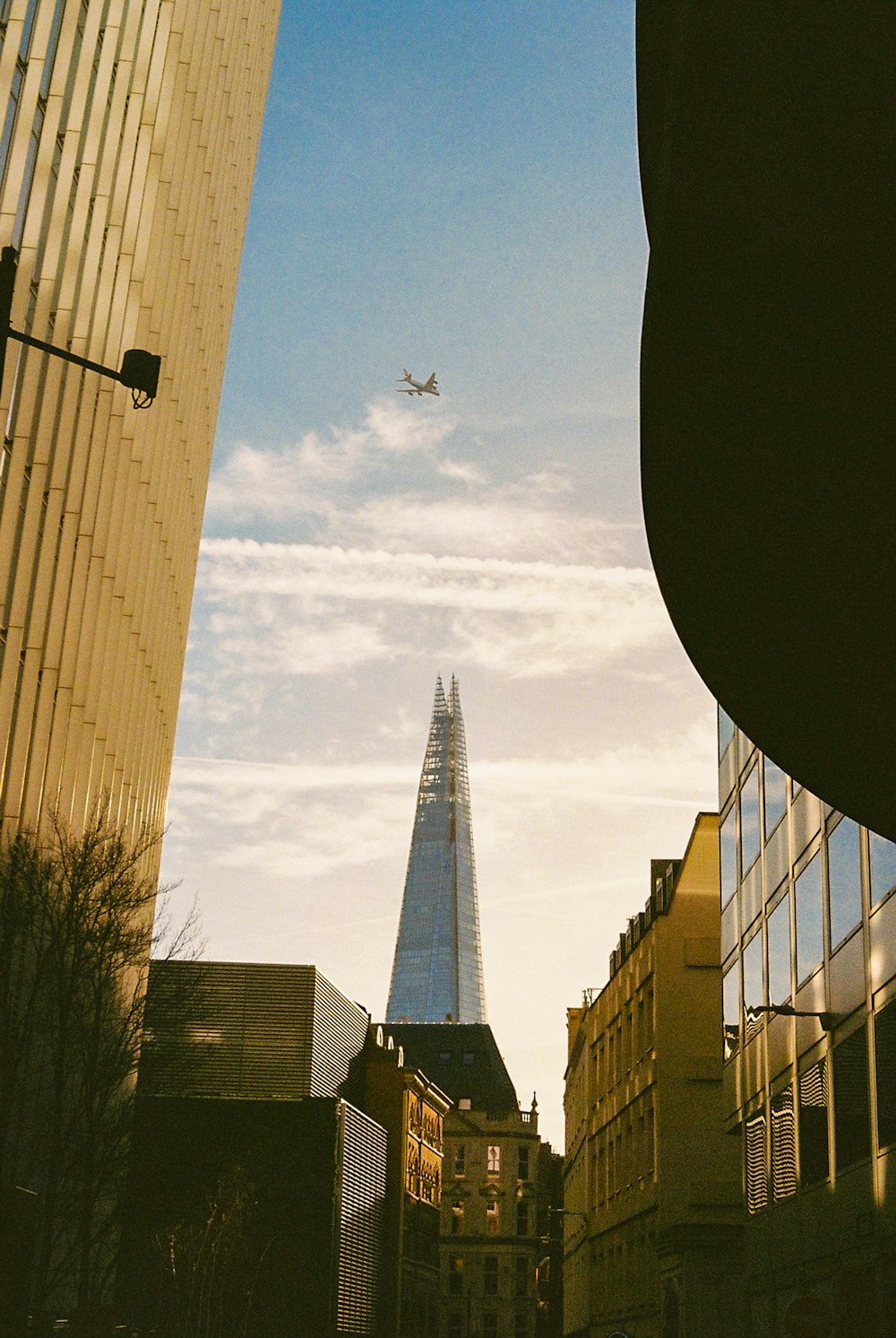 a plane flying over a city with tall buildings