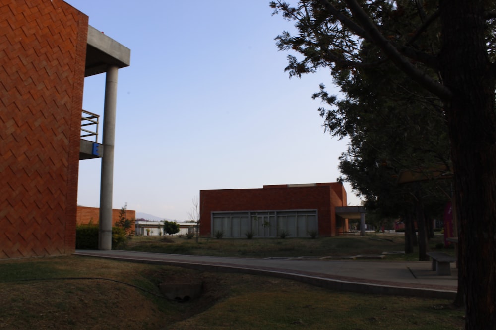 a red brick building sitting next to a tree