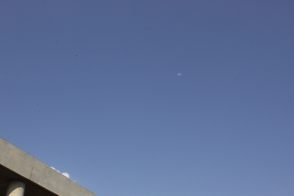 a plane flying in the sky over a bridge