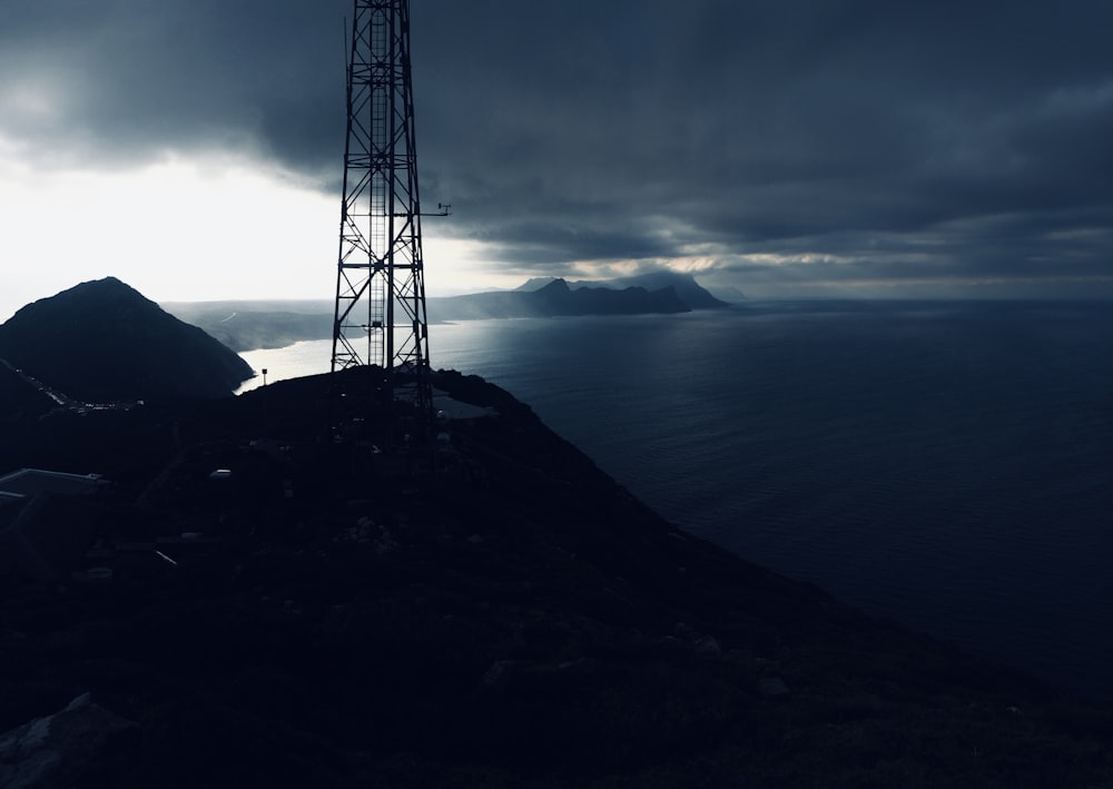 a radio tower sitting on top of a hill next to the ocean