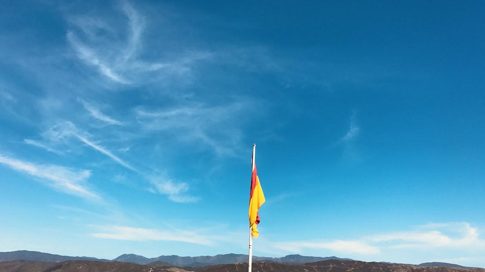 a yellow and red flag on a flagpole