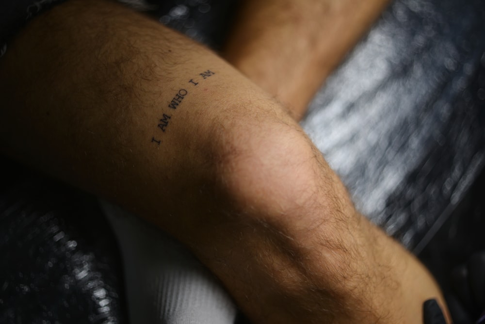 um close up de uma pessoa com uma tatuagem no braço