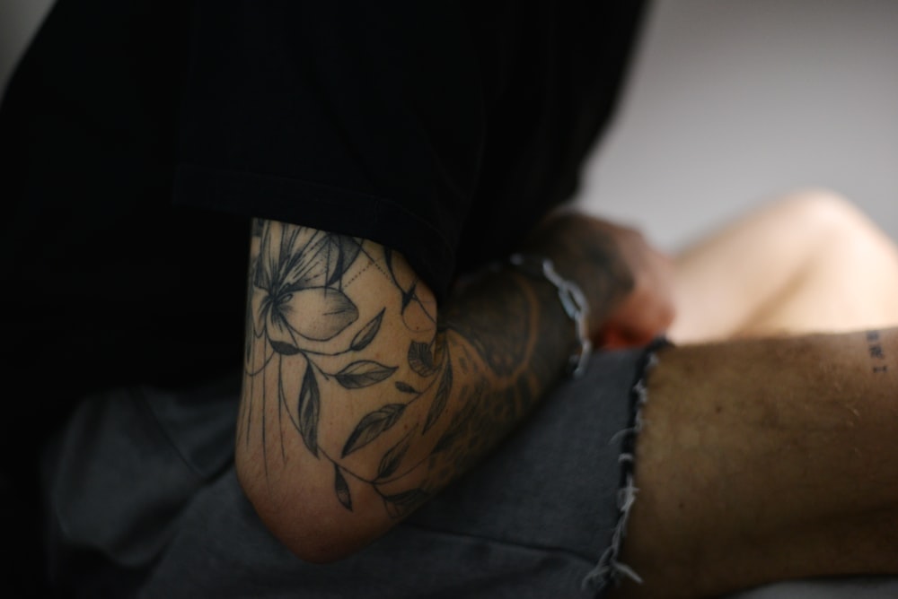 a man with a flower tattoo on his arm