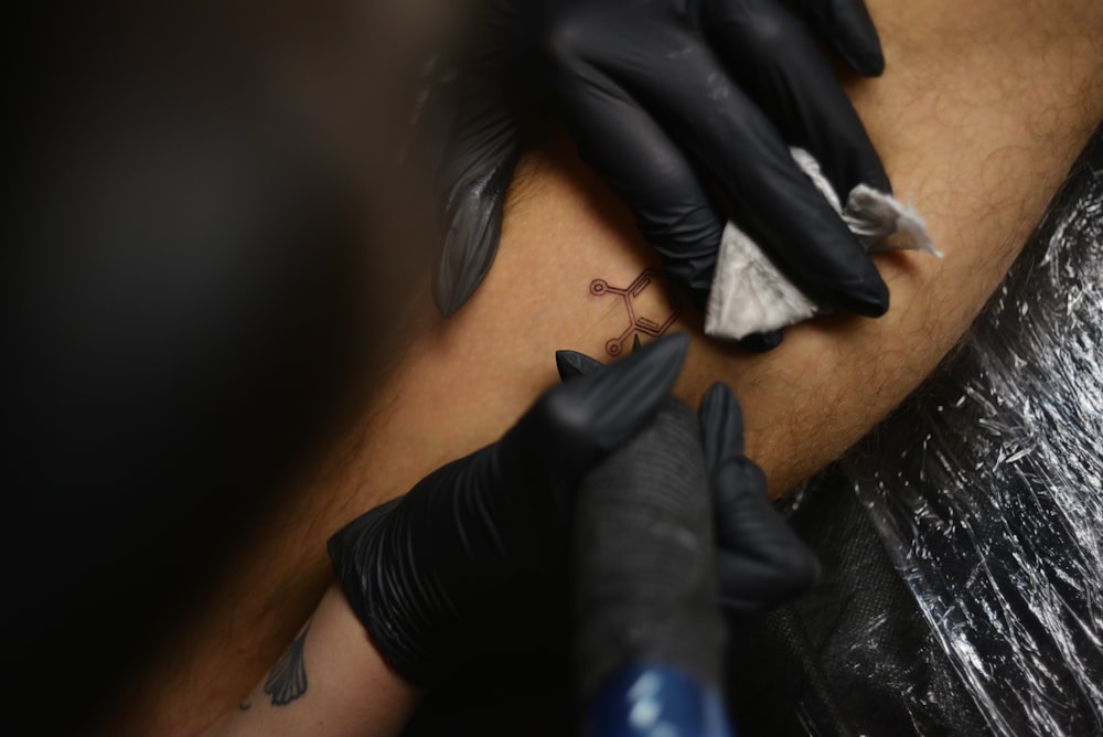 a man getting a tattoo on his arm