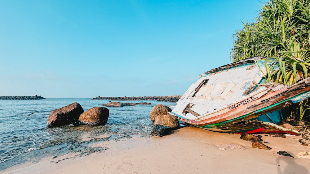 a boat sitting on top of a sandy beach
