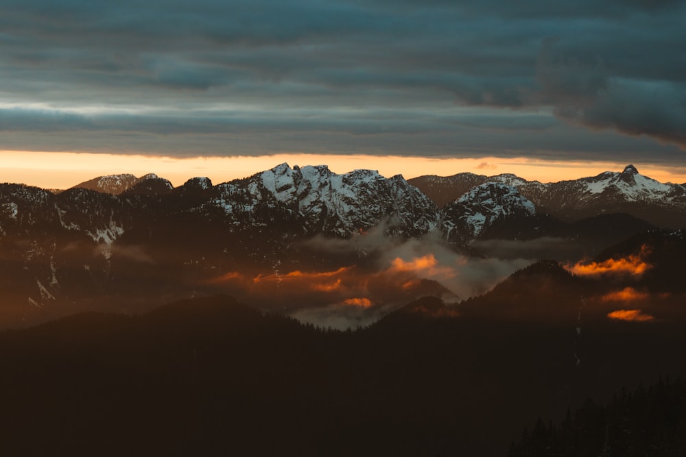 a view of a mountain range covered in clouds