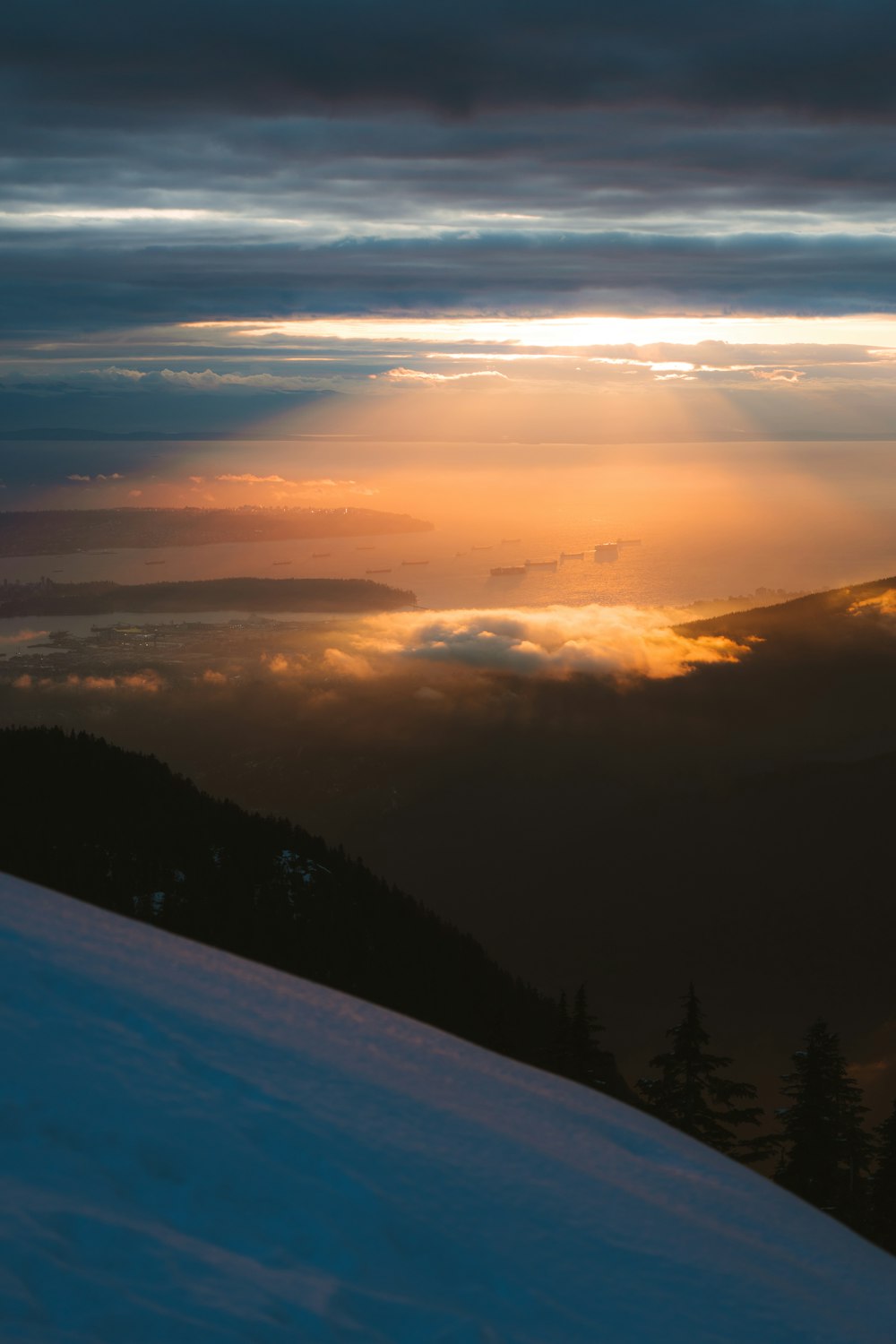 the sun is shining through the clouds over the mountains