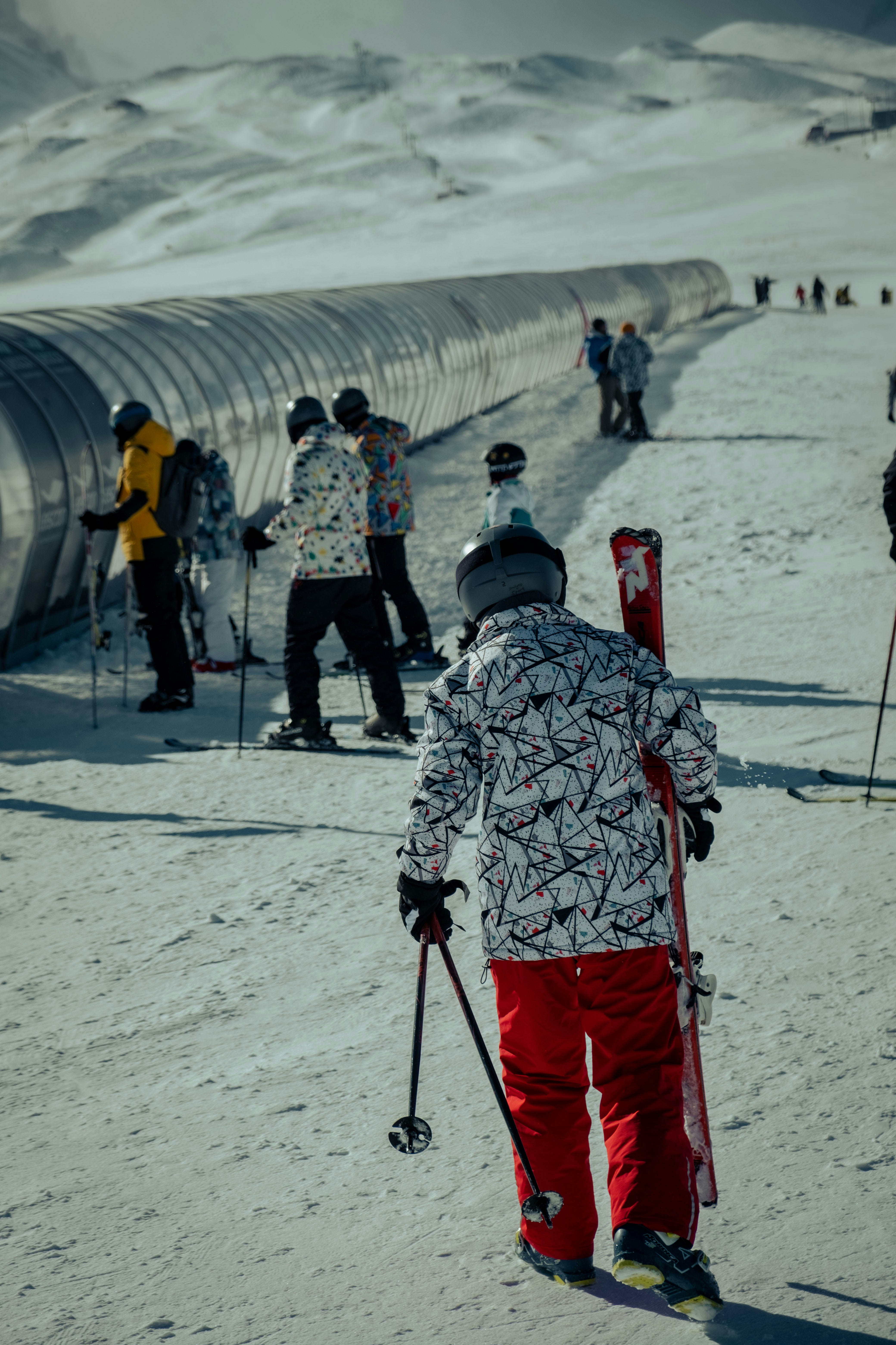 a group of people riding skis down a snow covered slope