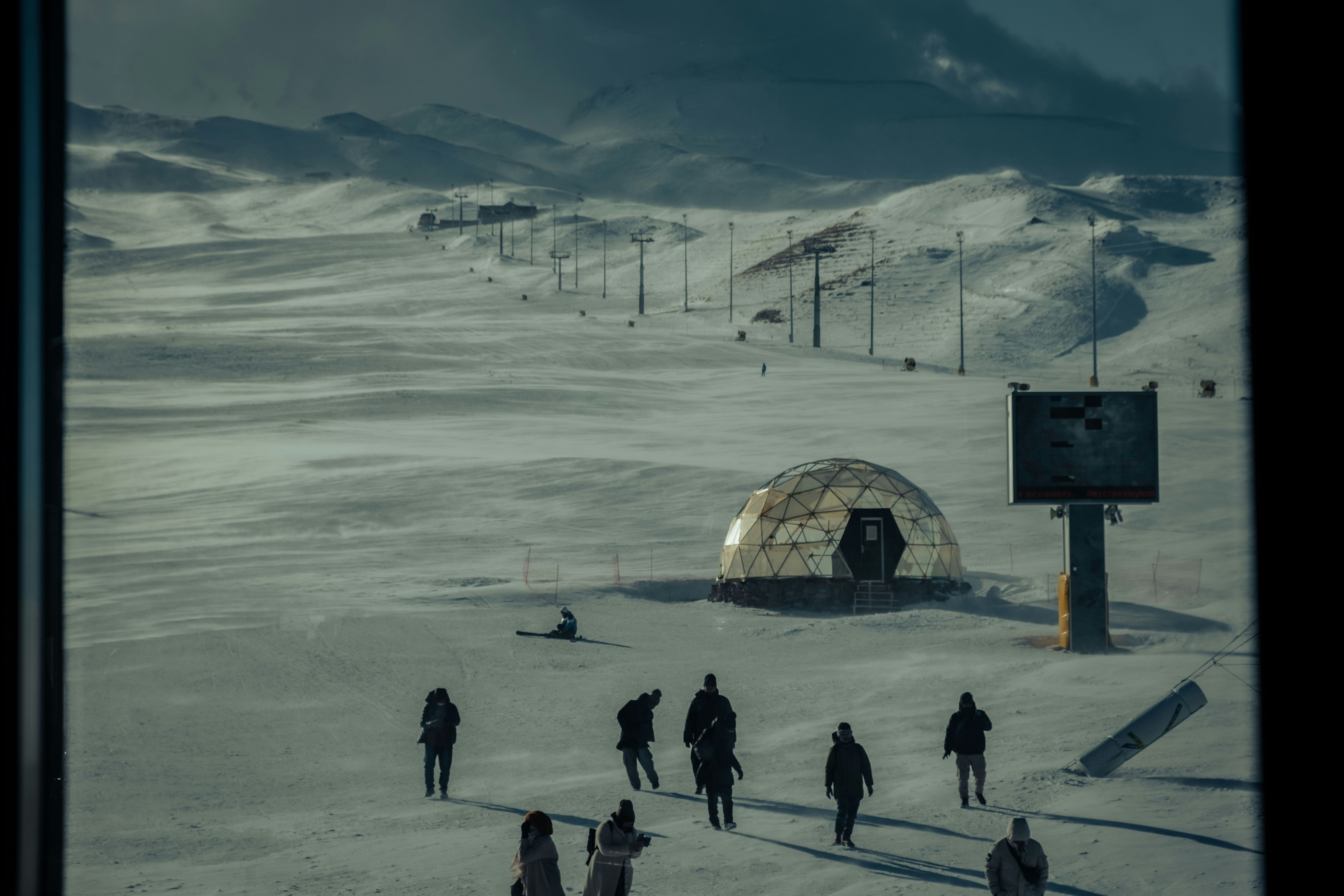a group of people walking across a snow covered field