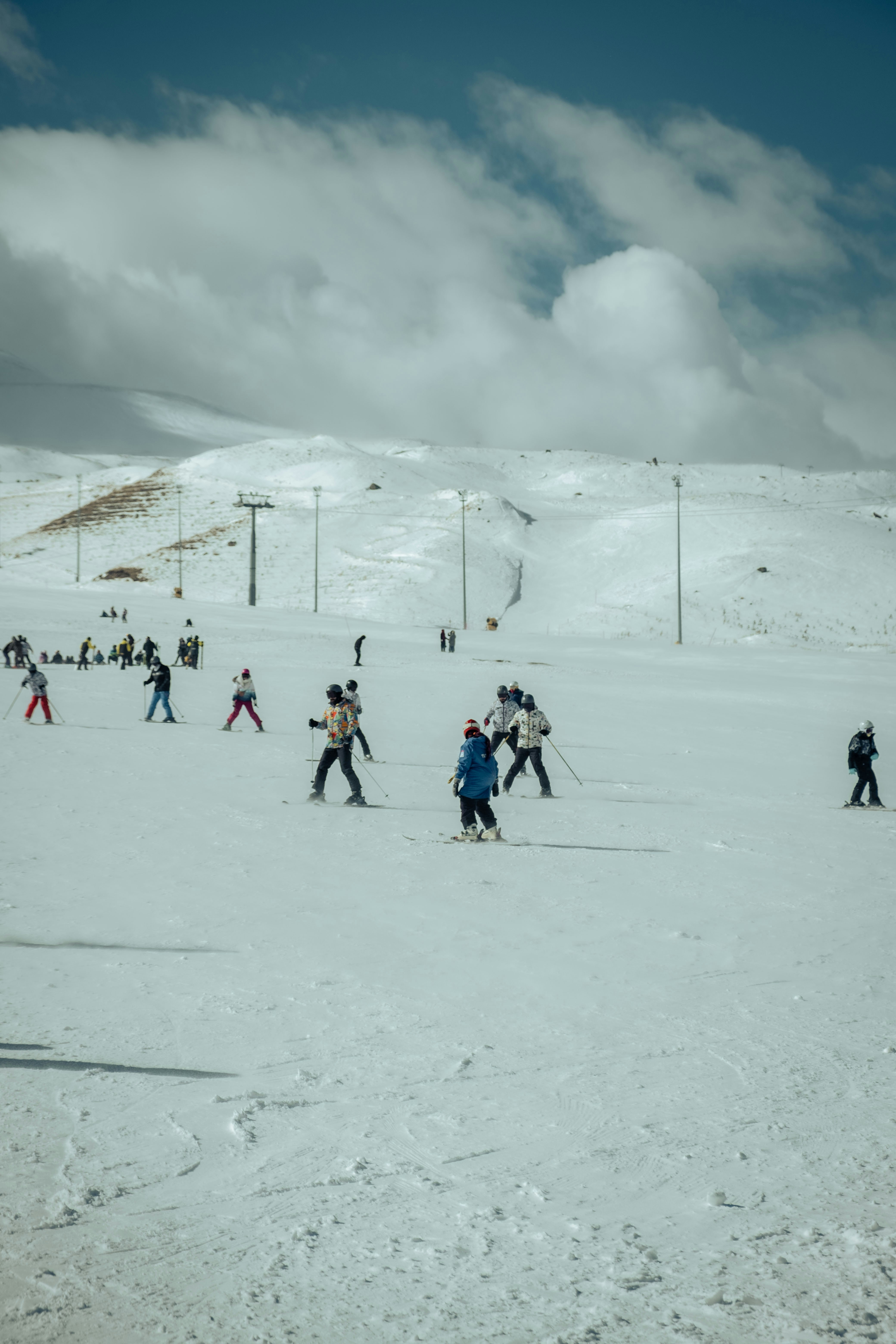a group of people riding skis down a snow covered slope