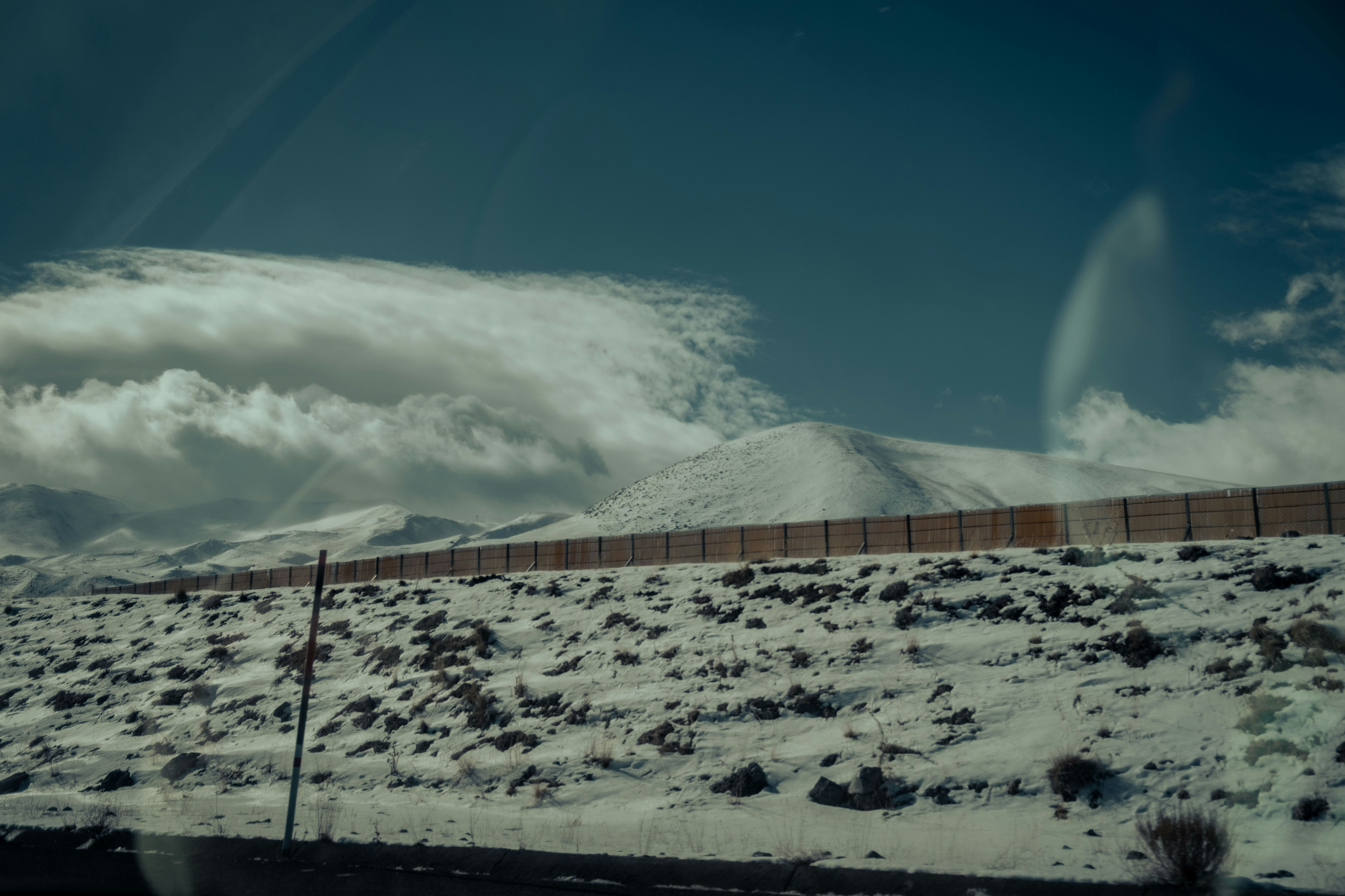 a snow covered field with a mountain in the background