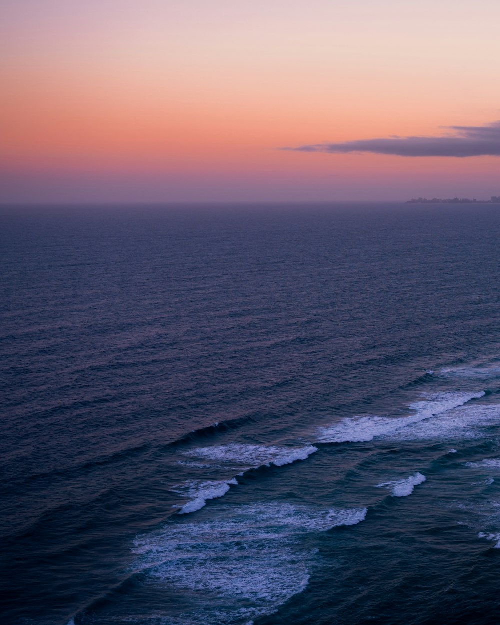 a view of the ocean at sunset from a high point of view
