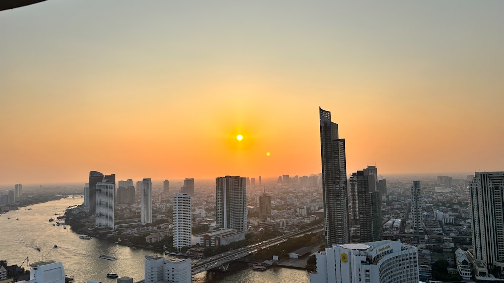 the sun is setting over a large city