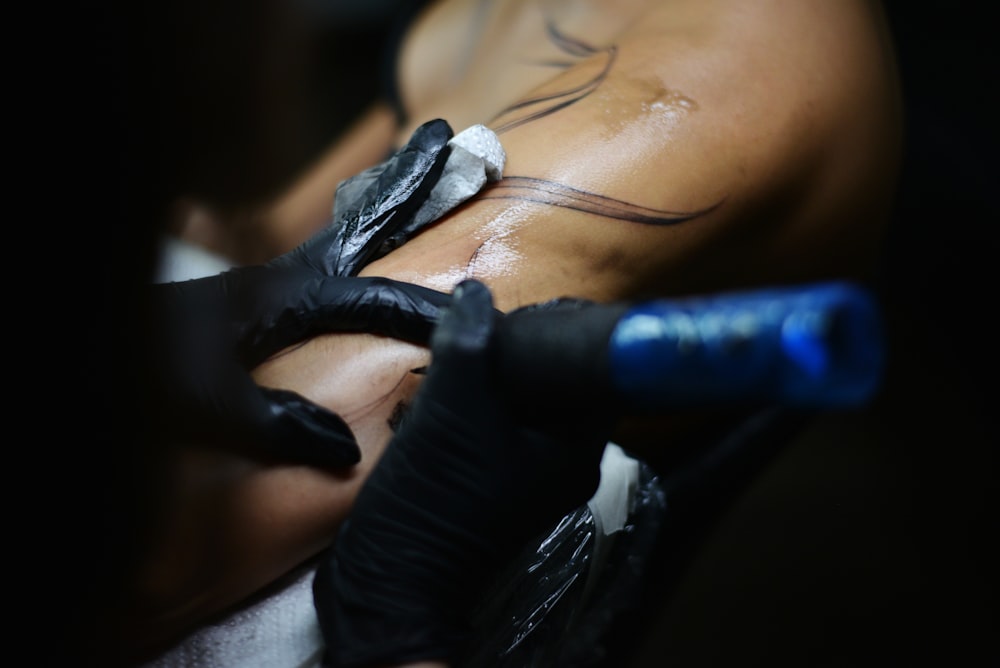 a man getting a tattoo done on his back
