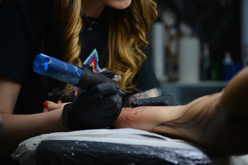 a woman getting a tattoo on her arm