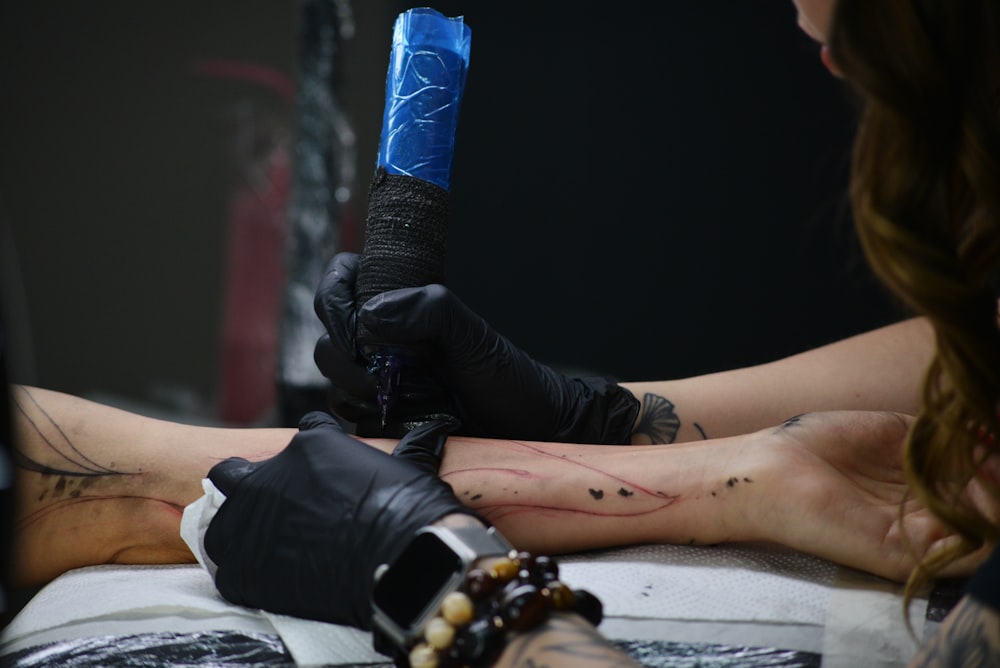 a woman getting a tattoo on her arm