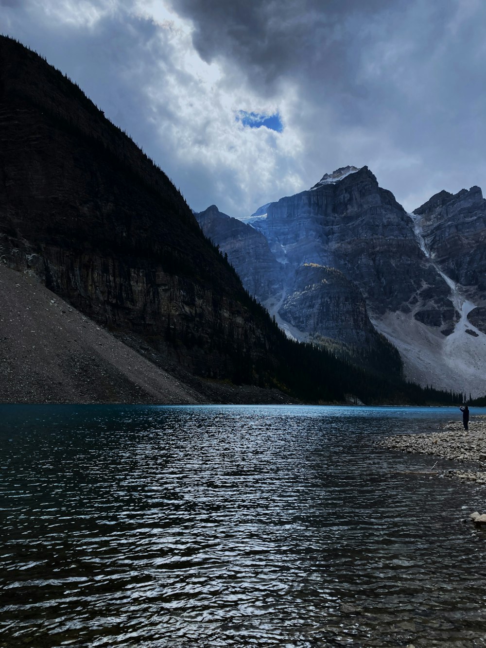 a man standing on a rock in the middle of a lake