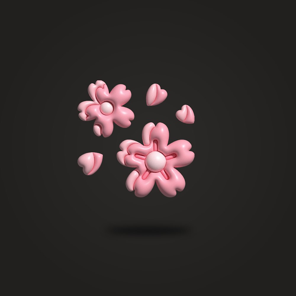 a group of pink flowers floating on top of a black surface