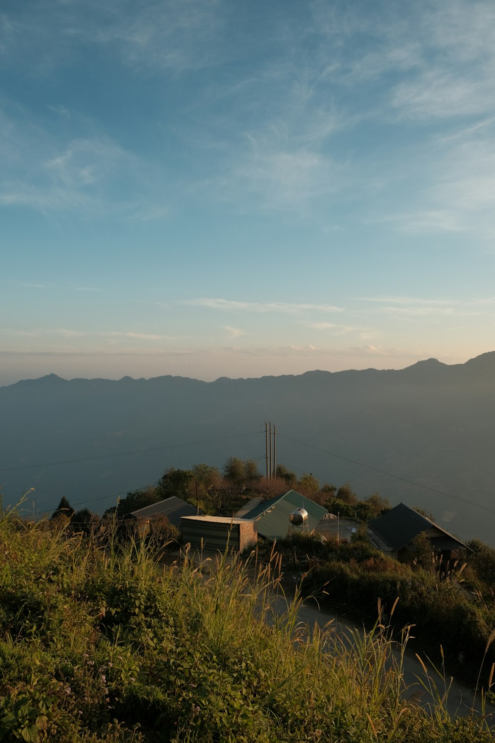 uma casa em uma colina com montanhas ao fundo