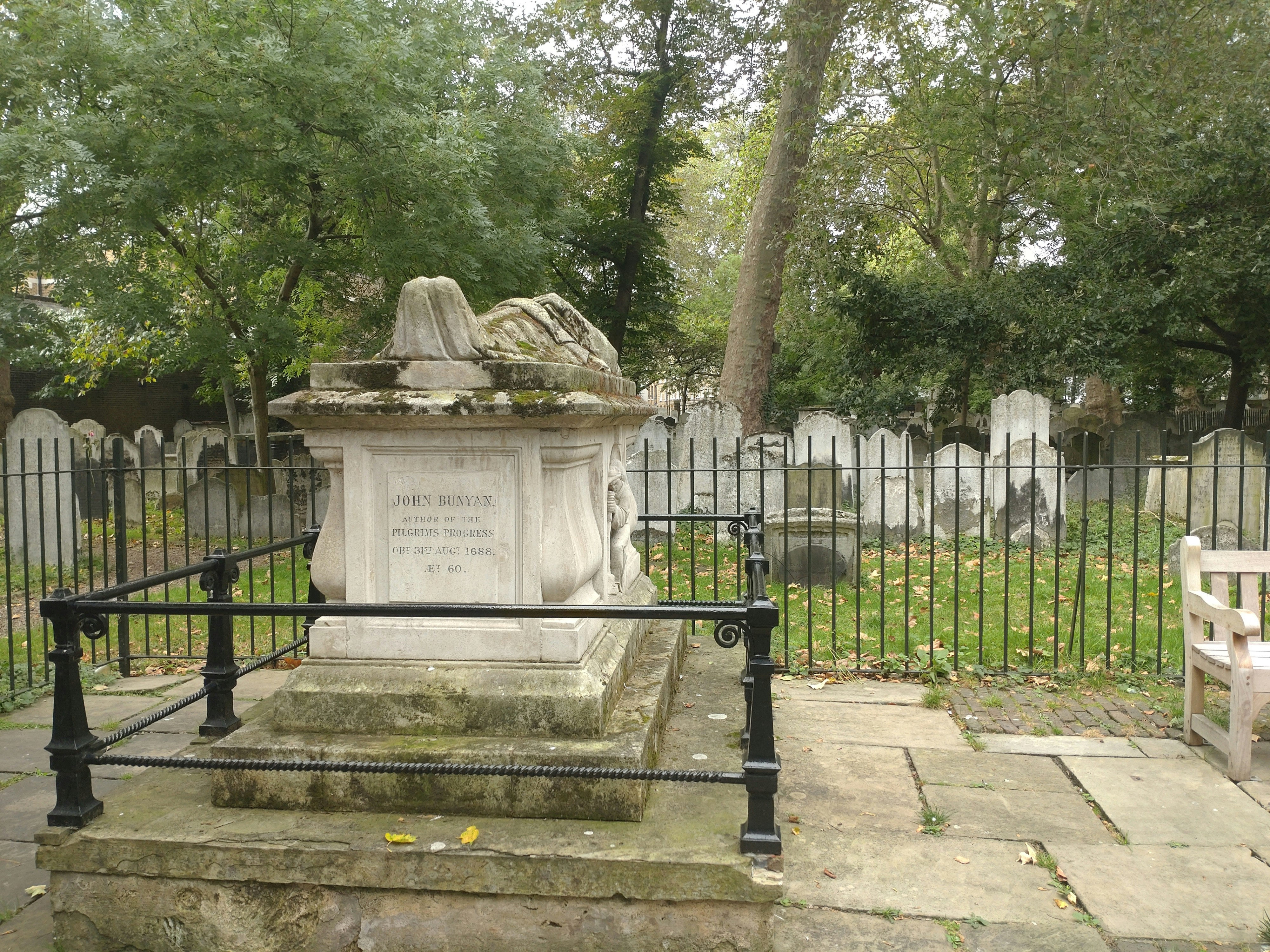 a cemetery with a statue and a fence
