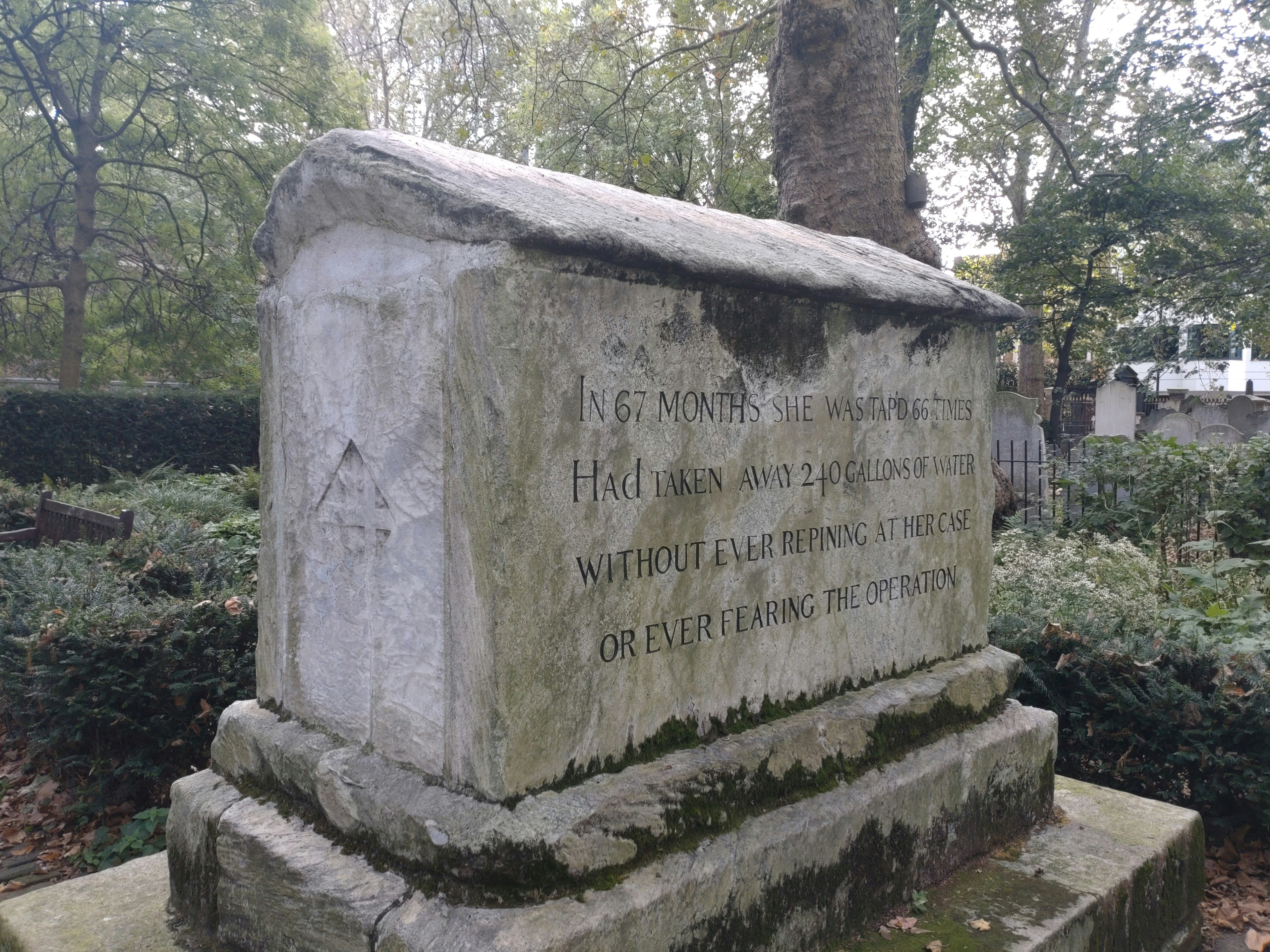 a stone monument with a tree in the background