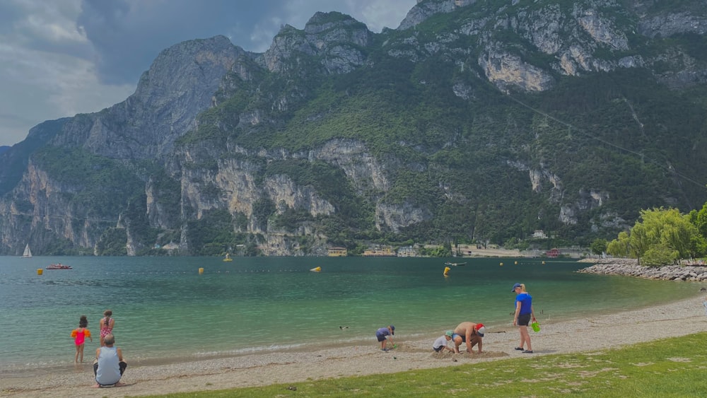 un groupe de personnes debout au sommet d’une plage de sable