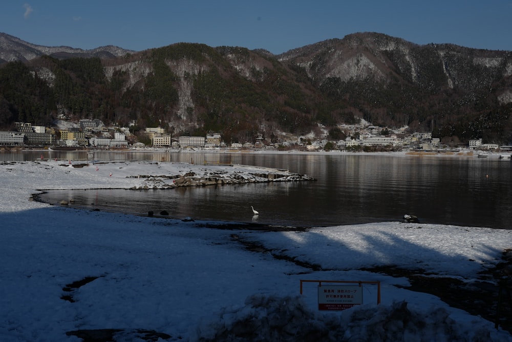 a body of water surrounded by snow covered mountains